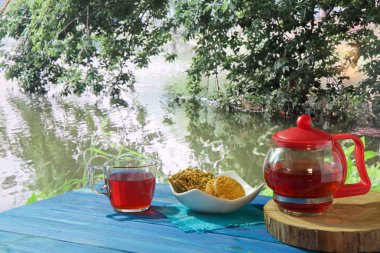 güzel manzaralar çeşitli arka planda mavi bir masada sıcak çay, Çaydanlık ve tatlılar