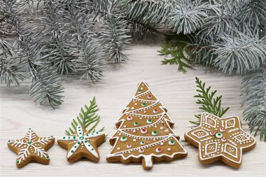 Beyaz ahşap arka plan üzerinde farklı Noel zencefilli kurabiye bir gruptur. Ağacın dalıarka. Renkli fotoğraf