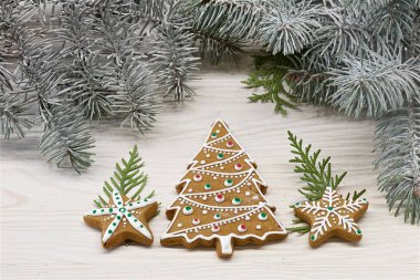 Beyaz ahşap arka plan üzerinde farklı Noel zencefilli kurabiye bir gruptur. Ağacın dalıarka. Renkli fotoğraf