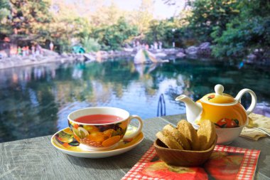 güzel manzaralar çeşitli arka planda mavi bir masada sıcak çay, Çaydanlık ve tatlılar