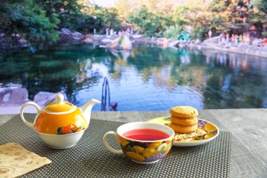 güzel manzaralar çeşitli arka planda mavi bir masada sıcak çay, Çaydanlık ve tatlılar