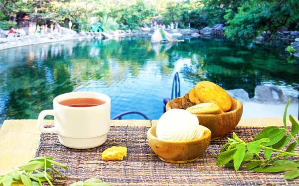 güzel manzaralar çeşitli arka planda mavi bir masada sıcak çay, Çaydanlık ve tatlılar