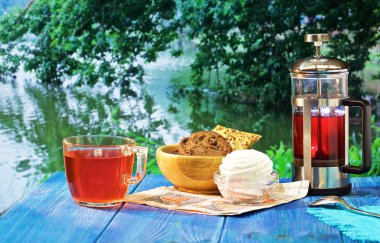 güzel manzaralar çeşitli arka planda mavi bir masada sıcak çay, Çaydanlık ve tatlılar