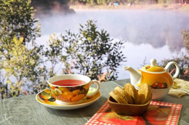 güzel manzaralar çeşitli arka planda mavi bir masada sıcak çay, Çaydanlık ve tatlılar