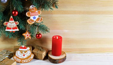 Süsler ile köknar ağacı dalları ile açık ahşap arka planda Noel Gingerbread ve hediyeler ile ahşap standları düzenlenmiştir.