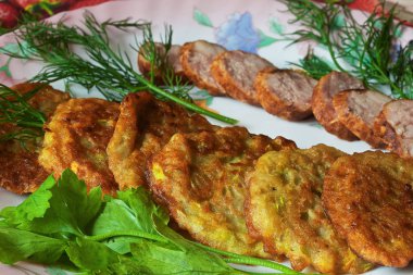 bir renk çanak üzerinde dilimlenmiş sosis ve otlar ile sıcak kabak börek.