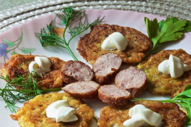 bir renk çanak üzerinde dilimlenmiş sosis ve otlar ile sıcak kabak börek.