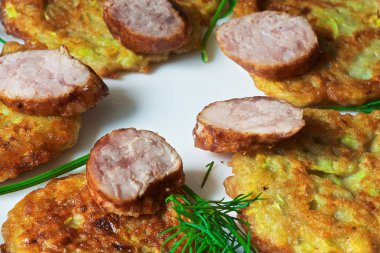 bir renk çanak üzerinde dilimlenmiş sosis ve otlar ile sıcak kabak börek.