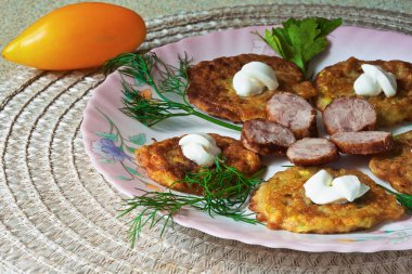 bir renk çanak üzerinde dilimlenmiş sosis ve otlar ile sıcak kabak börek.