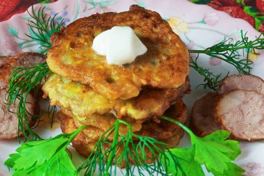 bir renk çanak üzerinde dilimlenmiş sosis ve otlar ile sıcak kabak börek.