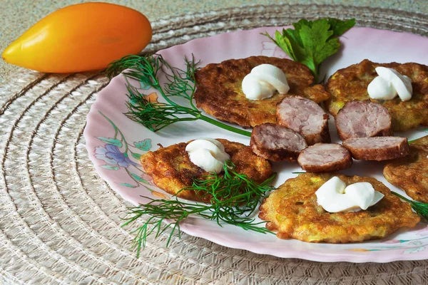 bir renk çanak üzerinde dilimlenmiş sosis ve otlar ile sıcak kabak börek.