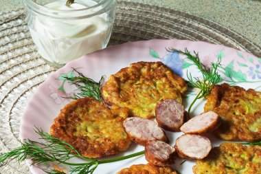 bir renk çanak üzerinde dilimlenmiş sosis ve otlar ile sıcak kabak börek.