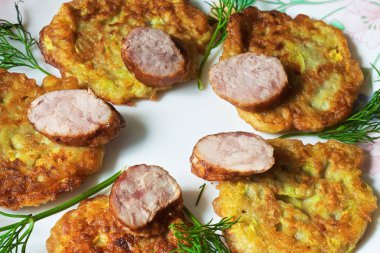 bir renk çanak üzerinde dilimlenmiş sosis ve otlar ile sıcak kabak börek.