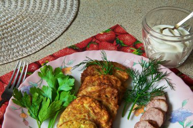 bir renk çanak üzerinde dilimlenmiş sosis ve otlar ile sıcak kabak börek.