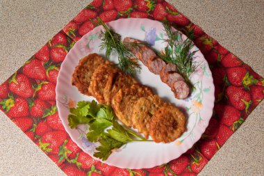 bir renk çanak üzerinde dilimlenmiş sosis ve otlar ile sıcak kabak börek.
