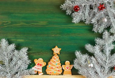 ladin dalları, Noel zencefilli kurabiye ve yeşil ahşap arka plan üzerinde süslemeleri. kartpostallar için