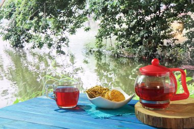 güzel manzaralar çeşitli arka planda mavi bir masada sıcak çay, Çaydanlık ve tatlılar