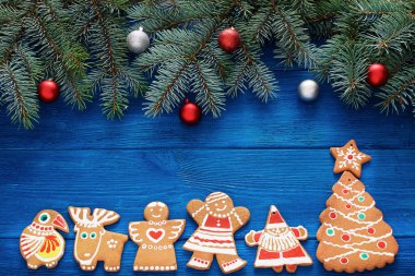 köknar dalları, mavi ahşap arka plan üzerinde noel zencefilli kurabiye ve süslemeleri. kartpostallar için