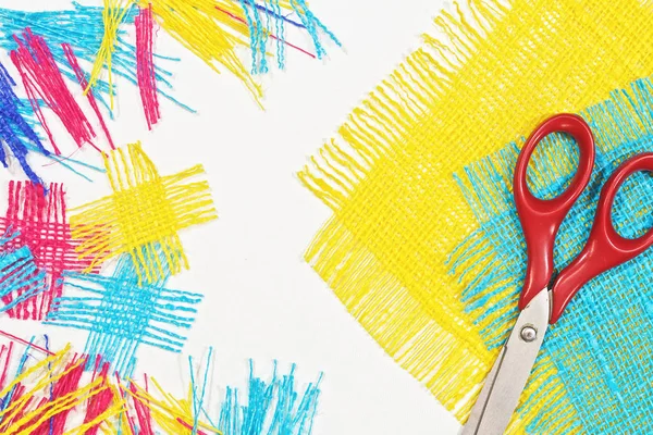 masaüzerinde çok renkli, pürüzlü pamuklu kumaş, iğne işi için alet ve iplikler