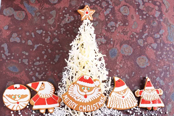 Homemade Christmas cookies, gifts and various decorations on a brown slate table. Festive christmas card