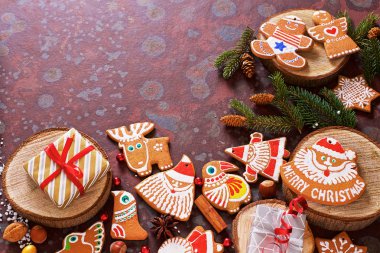 Kahverengi bir kayrak masada ev yapımı Noel çerezleri, hediyeler ve çeşitli süslemeler. Şenlikli noel kartı