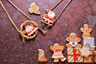 Kahverengi bir kayrak masada ev yapımı Noel çerezleri, hediyeler ve çeşitli süslemeler. Şenlikli noel kartı