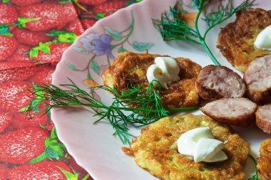 bir renk çanak üzerinde dilimlenmiş sosis ve otlar ile sıcak kabak börek.