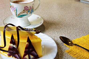 kahve fincan, renkli bir peçete ve hafif bir masa üzerinde limon kek