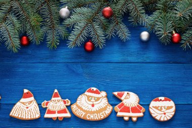 köknar dalları, mavi ahşap arka plan üzerinde noel zencefilli kurabiye ve süslemeleri. kartpostallar için