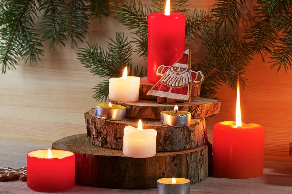 在淡淡的木制背景上 有冷杉枝条 还有圣诞姜饼 礼物和蜡烛 — 图库照片