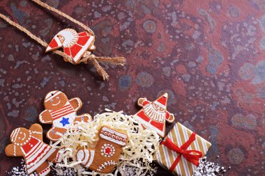 Kahverengi bir kayrak masada ev yapımı Noel çerezleri, hediyeler ve çeşitli süslemeler. Şenlikli noel kartı