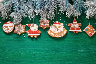 ladin dalları, Noel zencefilli kurabiye ve yeşil ahşap arka plan üzerinde süslemeleri. kartpostallar için