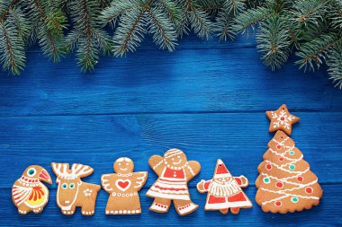 köknar dalları, mavi ahşap arka plan üzerinde noel zencefilli kurabiye ve süslemeleri. kartpostallar için