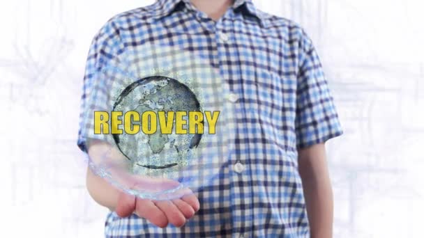 Jonge man toont een hologram van de planeet aarde en tekst Recovery — Stockvideo