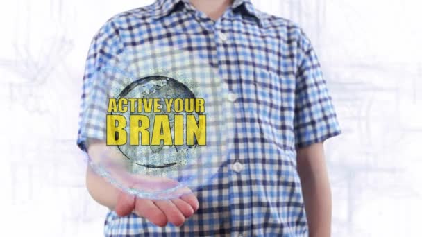 若い男が地球という惑星のホログラムと本文アクティブ、あなたの脳を示しています — ストック動画