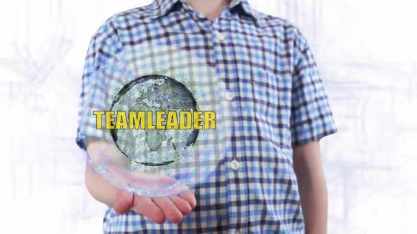 Jovem mostra um holograma do planeta Terra e texto Teamleader — Vídeo de Stock