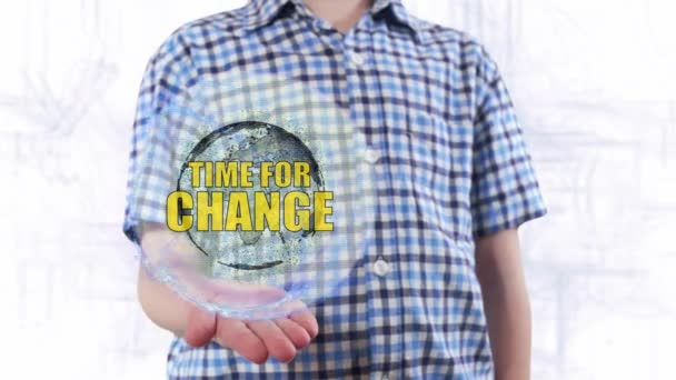 Jovem mostra um holograma do planeta Terra e texto Tempo de mudança — Vídeo de Stock