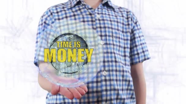 Giovane uomo mostra un ologramma del pianeta Terra e testo Il tempo è denaro — Video Stock