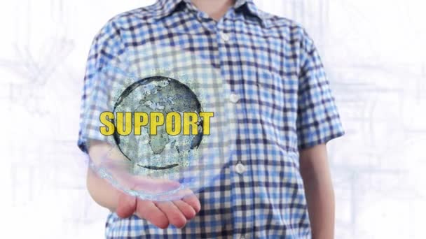 Young man shows a hologram of the planet Earth and text Support — Stock Video