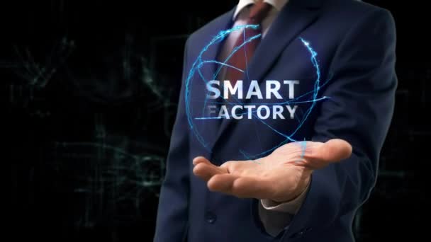 Бизнесмен показывает концептуальную голограмму Smart Factory на руке — стоковое видео