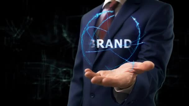 Businessman shows concept hologram Brand on his hand — Stock Video