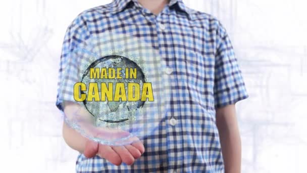 Joven muestra un holograma del planeta Tierra y texto Made in Canada — Vídeos de Stock