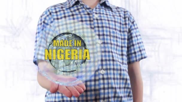 Ung man visar ett hologram av planeten jorden och text Made i Nigeria — Stockvideo