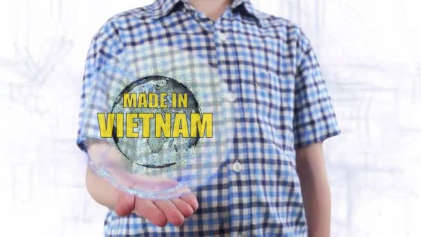 Joven muestra un holograma del planeta Tierra y texto Made in Vietnam — Vídeos de Stock