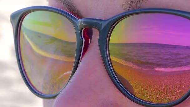 De zee en de lucht worden weerspiegeld in de zonnebril — Stockvideo