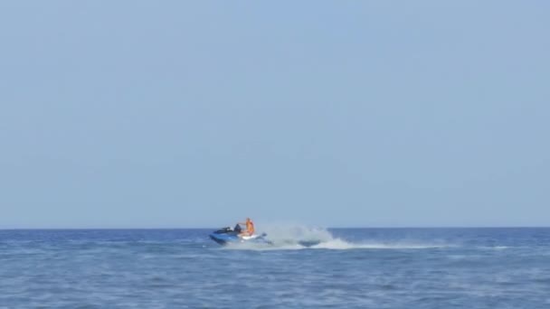 Onherkenbaar persoon is de zee rijden op een scooter water — Stockvideo