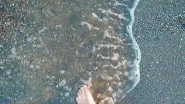 Las piernas están en primera línea de mar. Pies en la playa — Vídeos de Stock