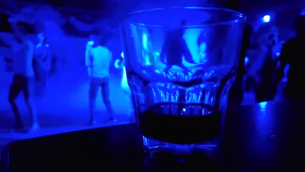 无法辨认的人跳舞在五颜六色的背景玻璃与饮料 — 图库视频影像
