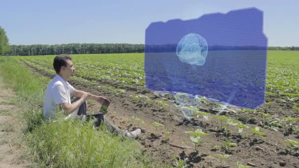 Człowiek pracuje z mózgu 3d holograficzny wystawa na skraju pola — Wideo stockowe