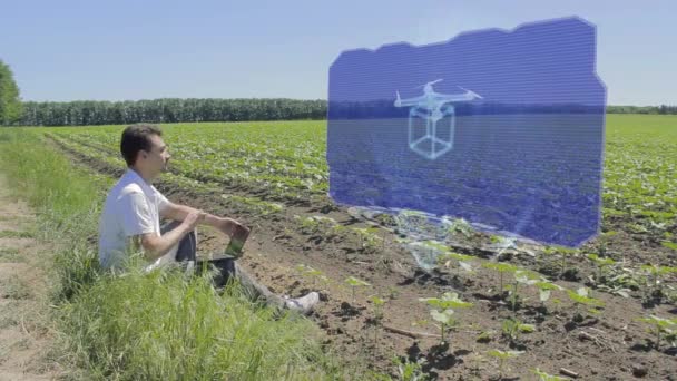 Man is working with 3D drone on holographic display on the edge of the field — Stock Video
